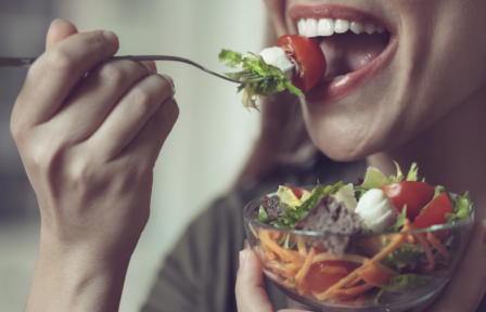 Femme méditant devant une assiette, symbole d’une alimentation consciente et apaisée.